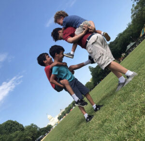 Four boys playing on the grass outside the US Capitol.
